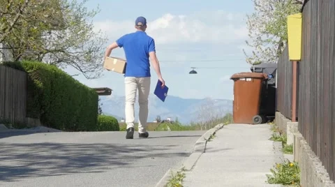Slow motion of a delivery guy with box walking down the street Stock-Footage 49789389