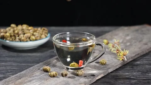 Slow Motion of Dendrobium Flower Falling Into Glass Tea Cup Stock Footage 339641092