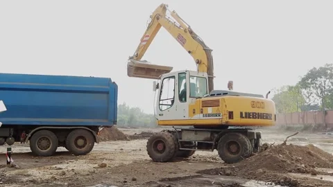 Slow motion of a digger digging a pit and throwing dirt. Stock Footage 148627535
