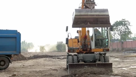 Slow motion of a digger digging a pit and throwing dirt. Stock Footage 148629424