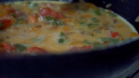 Slow motion, Dinner from eggs and red pepper is cooked in a frying pan. A beauti Stock Footage 102931554