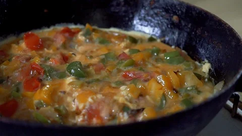 Slow motion, Dinner from eggs and red pepper is cooked in a frying pan. A beauti Stock Footage 102931573