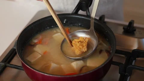 Slow motion dissolving miso into kenchin soup with a ladle in Japan Video stock 348196801