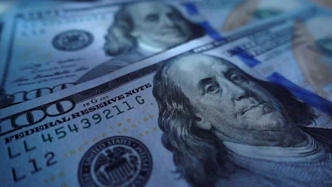 Slow motion dollar coin falls and rotates on one hundred dollar bills. Stock-Footage 112348553