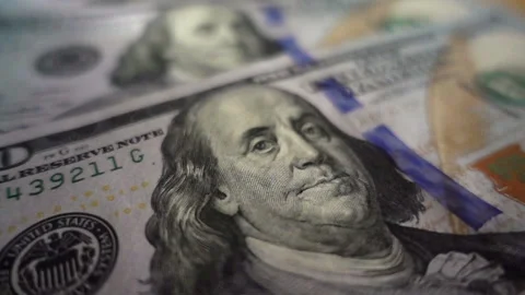 Slow motion dollar coin rotates on one hundred dollar bills. Stock Footage 112344598