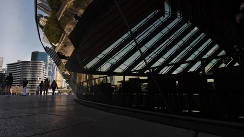 Slow motion dolly reflected tourists and cityscape at Sydney Opera House 4K Stock Footage 247513479