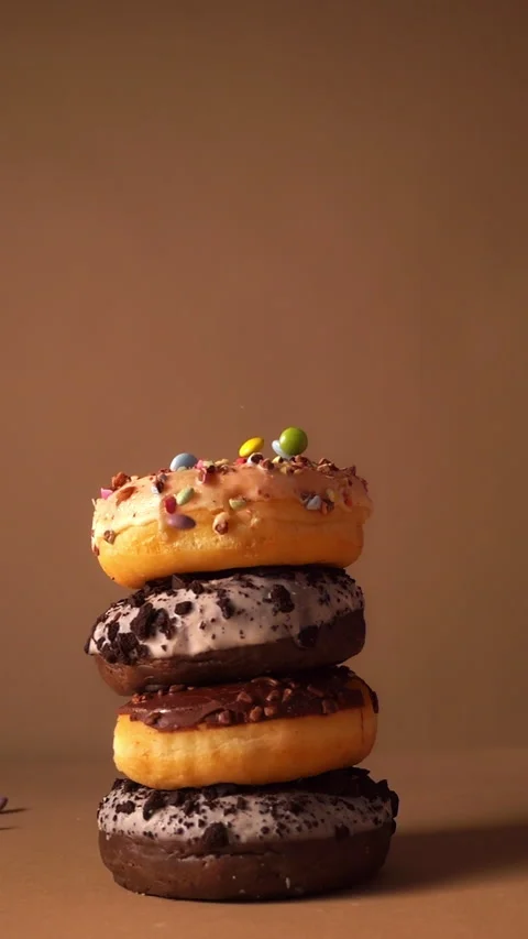 Slow Motion Donut Stack with Falling Colorful Candy Pieces 動画素材 331232473