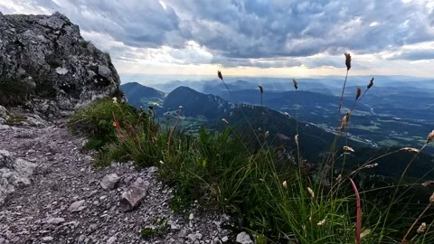 Slow-motion of dramatic clouds and wind-blown grass on a rocky mountain peak Видео 316144690