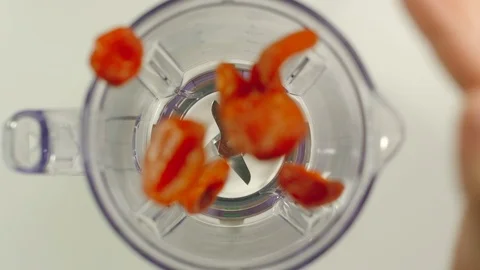 SLOW MOTION: Dried apricots fall into mixer Видео 97093002