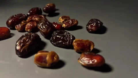 Slow Motion Dried Dates Falling onto Surface on Dark Background Stock Footage 328136922