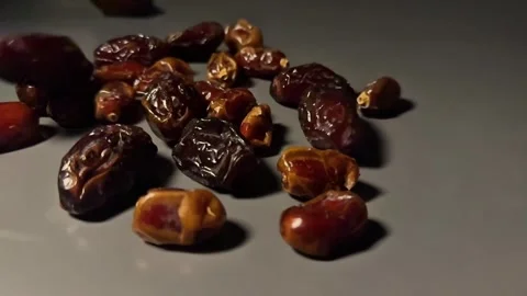Slow Motion Dried Dates Falling onto Surface on Dark Background Stock Footage 328136926