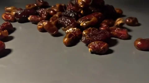 Slow Motion Dried Dates Falling onto Surface on Dark Background Video stock 328136937