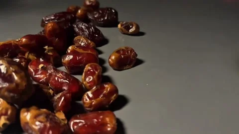 Slow Motion Dried Dates Falling onto Surface on Dark Background Video stock 328136940