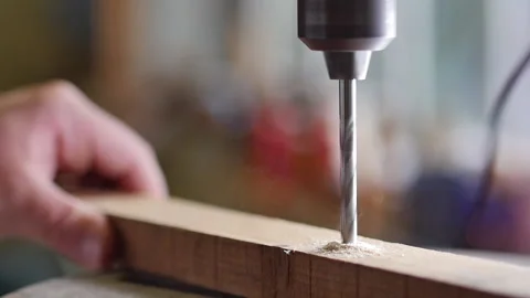 Slow motion of drill chuck with drill bit on piece of reclaimed wood. Stock Footage 140977610