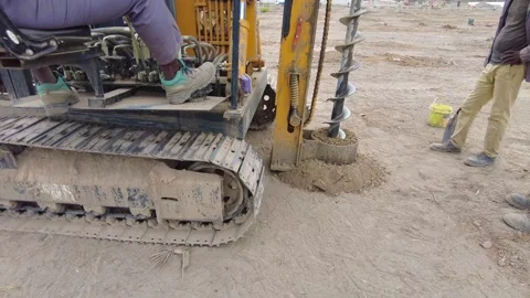 Slow motion of drilling rig digging the foundation for solar array concrete Vídeos de archivo 345852454
