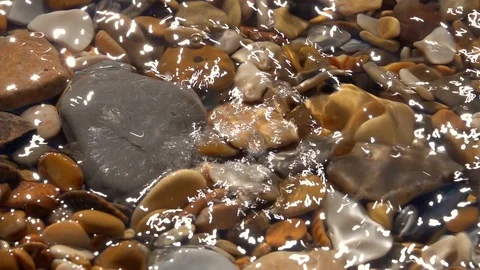 Slow motion of dripping on shallow pure water with pebble bottom close up. Stock Footage 98096884