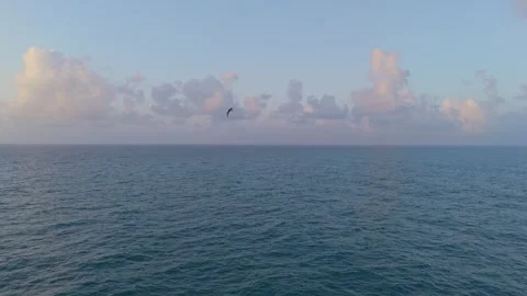 A slow-motion drone captures the sea at sunrise with blue and orange hues. .. Stock Footage 287135086