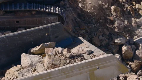 Slow motion drone closeup of excavator loading rocks into hopper Stock Footage 348337191