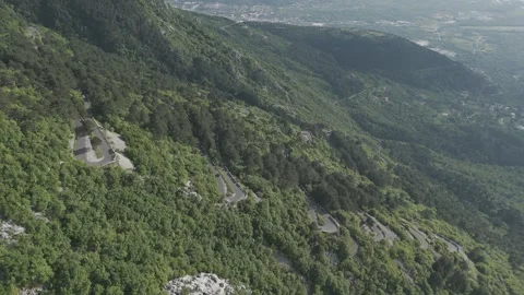 Slow Motion Drone Shot of Motorcyclists on Serpentine Road Above Kotor, Monteneg Stock Footage 310335405