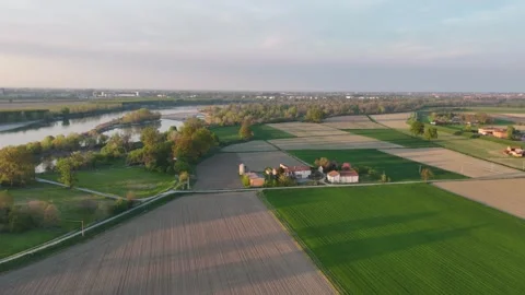 Slow-motion drone shot over Po River bend and patchwork farmland near Olza di Stock Footage 308444305