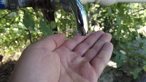 Slow motion of a drop falling from a tap into the palm of a human hand, Vídeos de archivo 281594383