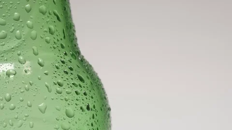 SLOW MOTION: Drop rolls down over a neck of cold green bottle Vídeo Stock 73178076
