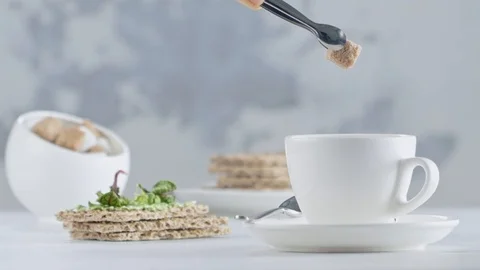 Slow motion drop of sugar cube into a cup with hot tea / coffee Stock Footage 103983356