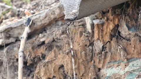 Slow motion. A drop of water falls from the drainpipe in early spring Stock Footage 107644139