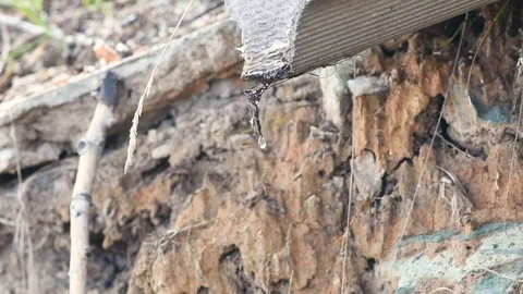 Slow motion. A drop of water falls from the drainpipe in early spring Stock Footage 107644223