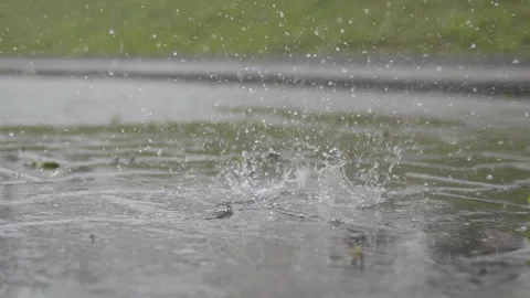 Slow motion a drop of water falls on the paving slabs in the rain. close-up Video stock 306145473