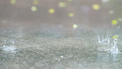 Slow motion droplet of rain falling on ground 動画素材 217867837
