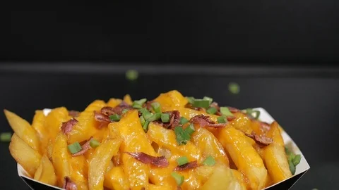 Slow Motion dropping chopped spring onions on french fries Stock Footage 124811341