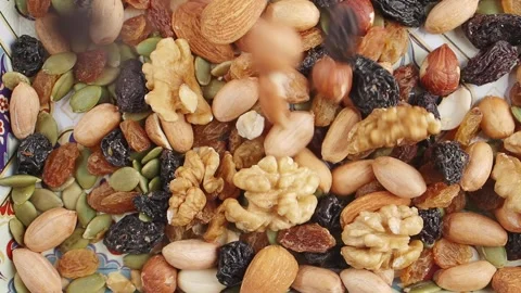 Slow motion of dropping Mix of nuts and dried fruits on a plate Stock Footage 342305790