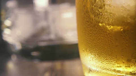 Slow motion drops on the misted glass and in the background pour into a glass Stock Footage 94032124
