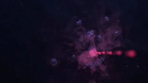 Slow motion. Drops of pink fluorescent paint fall into black water. 库存影片 133713718