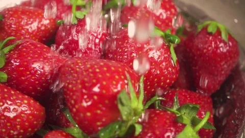 Slow motion drops of water fall on a strawberry in a colander Stock Footage 90257393
