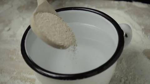 Slow motion dry yeast is poured into a mug Stock Footage 72782573