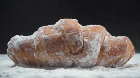 Slow motion of dusting of flour onto croissant isolated black background Stock Footage 278200141