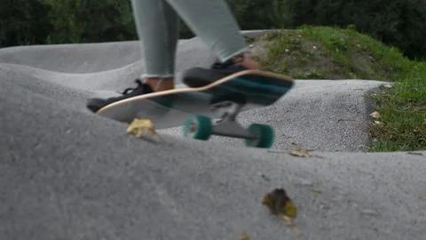 SLOW MOTION Dynamic close-up shot of woman in torn jeans riding a skateboard Stock Footage 118931078