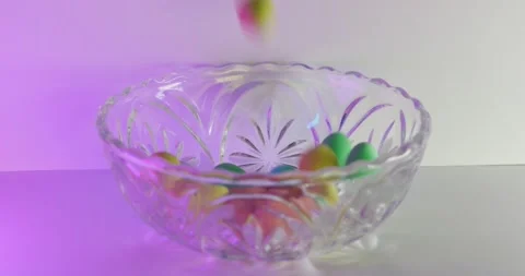 Slow motion of easter candies dropping into bowl Stock Footage 149712375