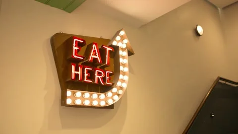 Slow motion of 'Eat Here' neon sign hang... | Stock Video | Pond5