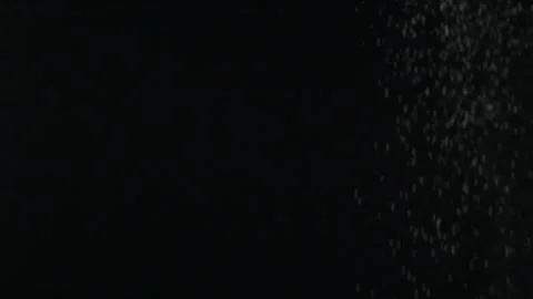 Slow motion effect of powder, dust, snow particles falling on black background Stock Footage 145785669