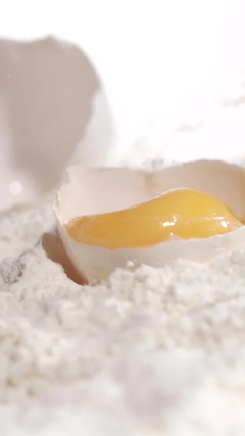 Slow motion of egg breaking and yolk dropping Stock Footage 344987362
