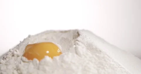 Slow motion of an egg breaking into flour Stock Footage 344987038