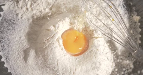 Slow motion of egg yolk mixing with flour during baking process Stock Footage 341903654