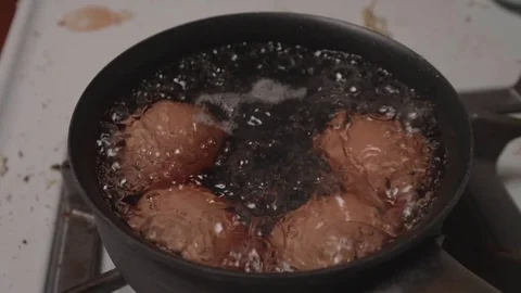 Slow Motion Eggs Boiling in Pot on Stove Stock Footage 80176330