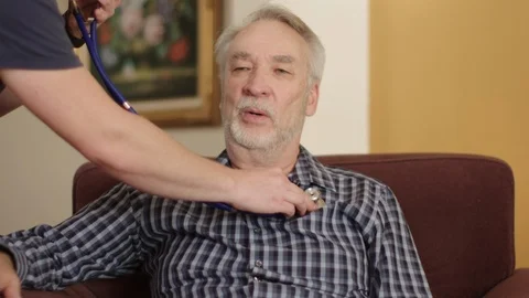 Slow motion, elderly senior man at home having his breathing checked by nurse Stock Footage 95685080