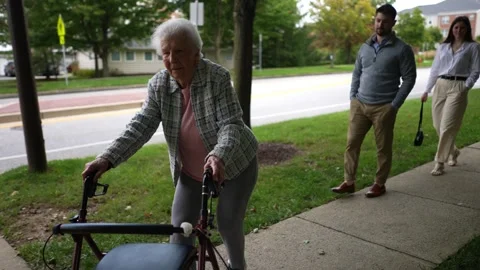 Slow motion of elderly senior old woman using walker for mobility on sidewalk Stock Footage 253756936