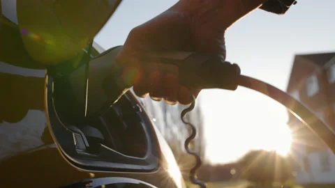 Slow motion Electric car plugged in outside house Stock Footage 169449907
