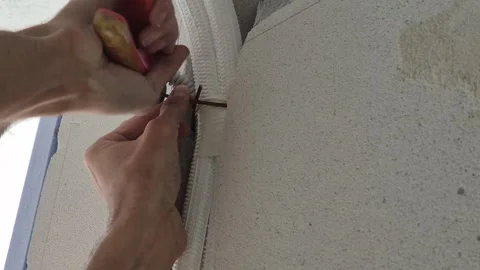 Slow motion electrician fixing corrugated conduit pipe into wall groove. 動画素材 339612719